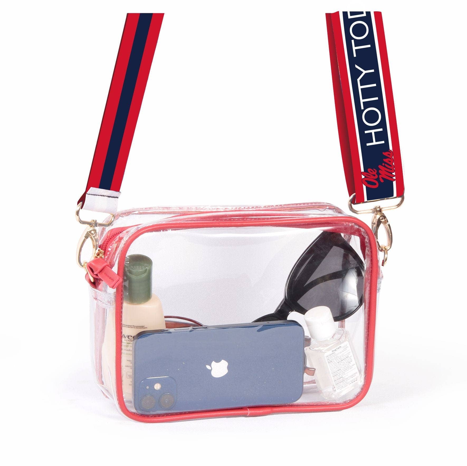A clear vinyl handbag with red trim and brass hardware, featuring a mobile phone, sunglasses, and a water bottle inside. It has two straps, one with a 'HOTY TOR' pattern and the other in red and blue.