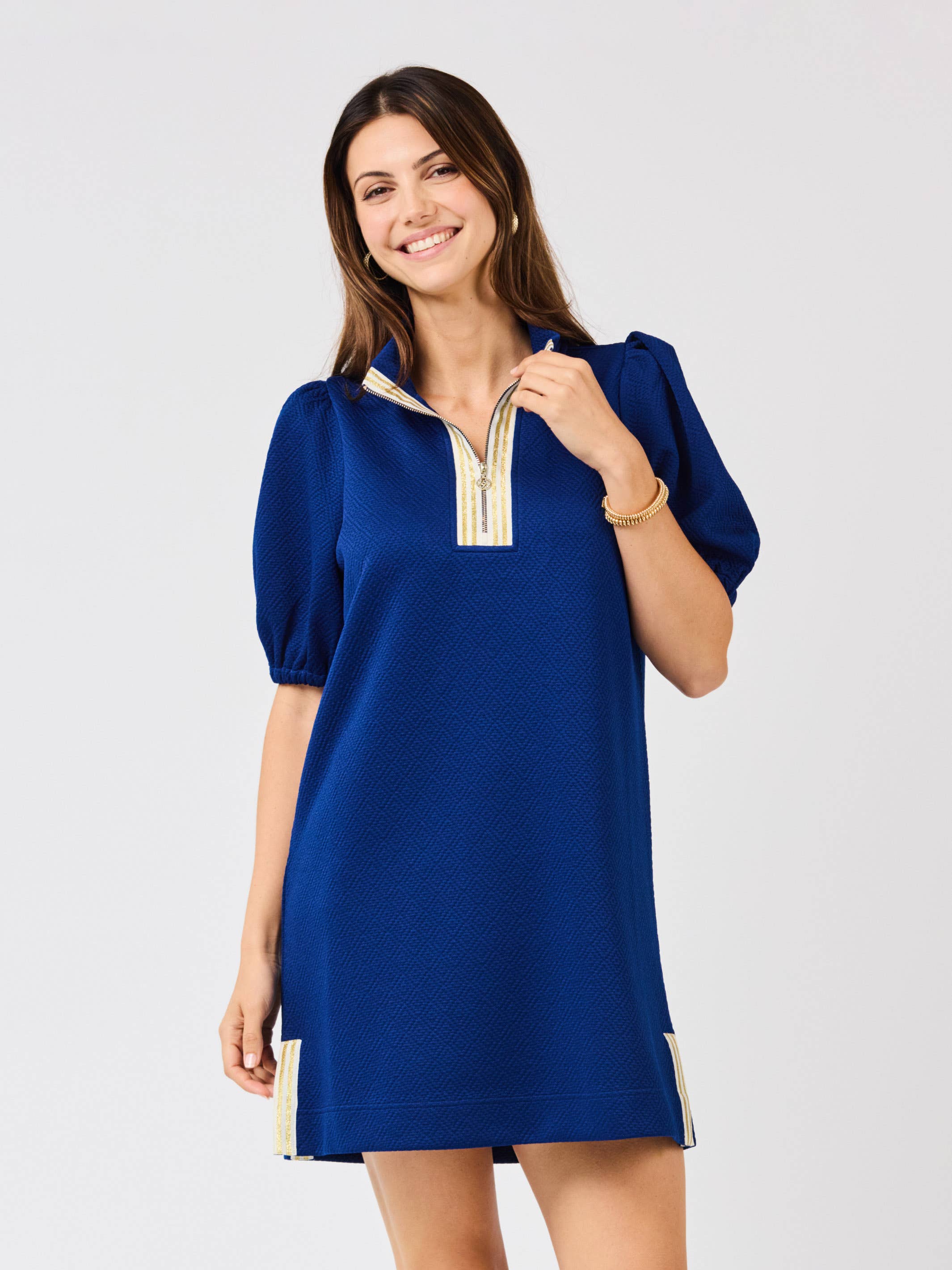Woman wearing a blue dress with a zipper on a light gray background